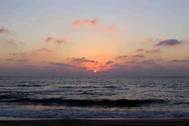Kuzey İsrail'de Akdeniz'de ufukta güneş batıyor ve gece çöküyor. 