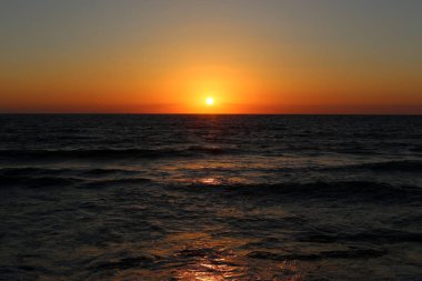 Kuzey İsrail'de Akdeniz'de ufukta güneş batıyor, gün bitiyor ve gece çöküyor. 