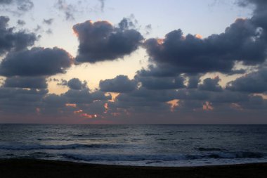 Kuzey İsrail'de Akdeniz'de ufukta güneş batıyor, gün bitiyor ve gece çöküyor. 