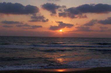 Kuzey İsrail'de Akdeniz'de ufukta güneş batıyor, gün bitiyor ve gece çöküyor. 