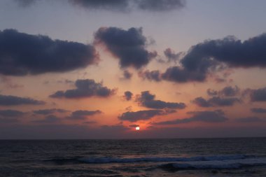 Kuzey İsrail'de Akdeniz'de ufukta güneş batıyor, gün bitiyor ve gece çöküyor. 