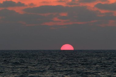 Kuzey İsrail'de Akdeniz'de ufukta güneş batıyor, gün bitiyor ve gece çöküyor. 