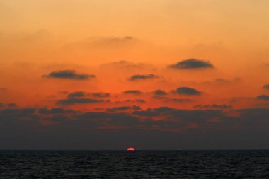 Kuzey İsrail'de Akdeniz'de ufukta güneş batıyor, gün bitiyor ve gece çöküyor. 
