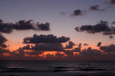 Kuzey İsrail'de Akdeniz'de ufukta güneş batıyor, gün bitiyor ve gece çöküyor. 
