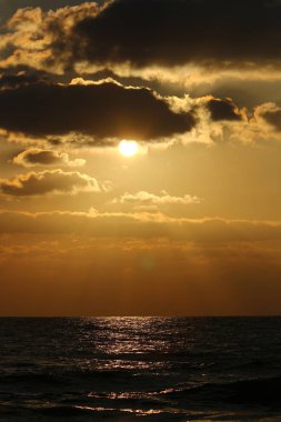 Kuzey İsrail'de Akdeniz'de ufukta güneş batıyor, gün bitiyor ve gece çöküyor. 