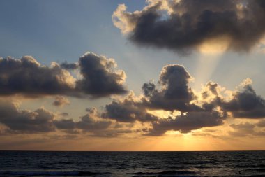 Kuzey İsrail'de Akdeniz'de ufukta güneş batıyor, gün bitiyor ve gece çöküyor. 