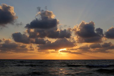 Kuzey İsrail'de Akdeniz'de ufukta güneş batıyor, gün bitiyor ve gece çöküyor. 