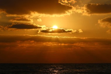 Kuzey İsrail'de Akdeniz'de ufukta güneş batıyor, gün bitiyor ve gece çöküyor. 