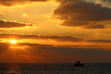 Kuzey İsrail'de Akdeniz'de ufukta güneş batıyor, gün bitiyor ve gece çöküyor. 