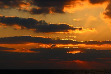 Kuzey İsrail'de Akdeniz'de ufukta güneş batıyor, gün bitiyor ve gece çöküyor. 
