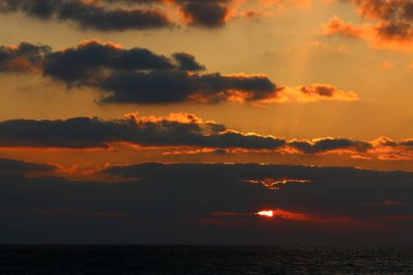 Kuzey İsrail'de Akdeniz'de ufukta güneş batıyor, gün bitiyor ve gece çöküyor. 