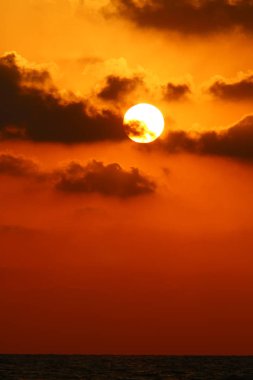 Kuzey İsrail'de Akdeniz'de ufukta güneş batıyor, gündüz bitiyor ve gece çöküyor 