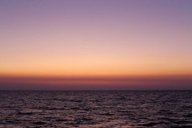 Kuzey İsrail'de Akdeniz'de ufukta güneş batıyor, gündüz bitiyor ve gece çöküyor 