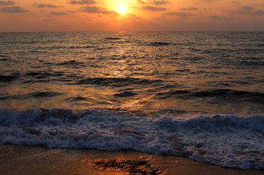 Kuzey İsrail'de Akdeniz'de ufukta güneş batıyor, gündüz bitiyor ve gece çöküyor 