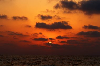 Kuzey İsrail'de Akdeniz'de ufukta güneş batıyor, gündüz bitiyor ve gece çöküyor 