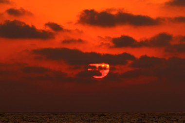 Kuzey İsrail'de Akdeniz'de ufukta güneş batıyor, gündüz bitiyor ve gece çöküyor 