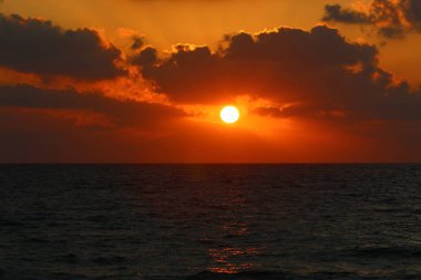 Kuzey İsrail'de Akdeniz'de ufukta güneş batıyor, gündüz bitiyor ve gece çöküyor 