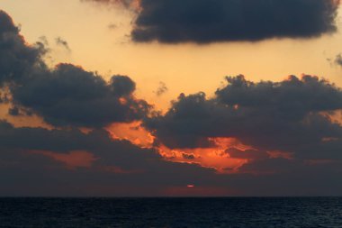Kuzey İsrail'de Akdeniz'de ufukta güneş batıyor, gündüz bitiyor ve gece çöküyor 