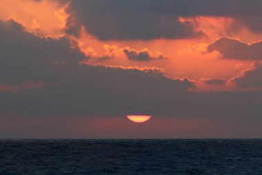 Kuzey İsrail'de Akdeniz'de ufukta güneş batıyor, gündüz bitiyor ve gece çöküyor 