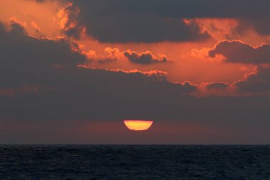 Kuzey İsrail'de Akdeniz'de ufukta güneş batıyor, gündüz bitiyor ve gece çöküyor 