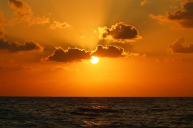 Kuzey İsrail'de Akdeniz'de ufukta güneş batıyor, gündüz bitiyor ve gece çöküyor 