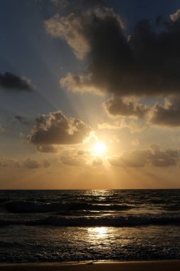 Kuzey İsrail'de Akdeniz'de ufukta güneş batıyor, gündüz bitiyor ve gece çöküyor 