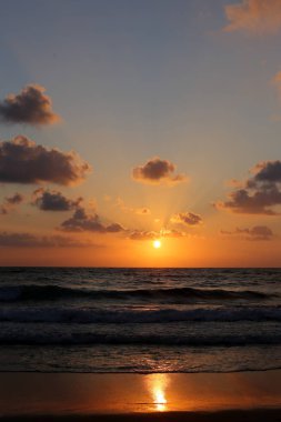 Kuzey İsrail'de Akdeniz'de ufukta güneş batıyor, gündüz bitiyor ve gece çöküyor 