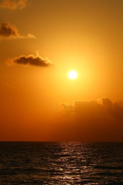 Kuzey İsrail'de Akdeniz'de ufukta güneş batıyor, gündüz bitiyor ve gece çöküyor 