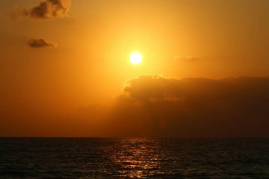 Kuzey İsrail'de Akdeniz'de ufukta güneş batıyor, gündüz bitiyor ve gece çöküyor 