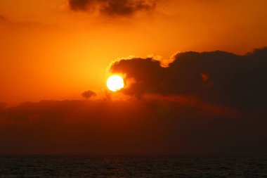 Kuzey İsrail'de Akdeniz'de ufukta güneş batıyor, gündüz bitiyor ve gece çöküyor 