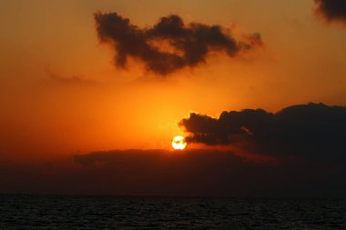 Kuzey İsrail'de Akdeniz'de ufukta güneş batıyor, gündüz bitiyor ve gece çöküyor 