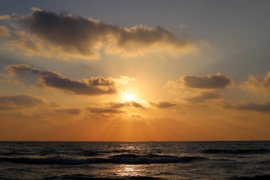 Kuzey İsrail'de Akdeniz'de ufukta güneş batıyor, gündüz bitiyor ve gece çöküyor 