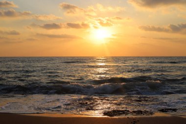 Kuzey İsrail'de Akdeniz'de ufukta güneş batıyor, gündüz bitiyor ve gece çöküyor 