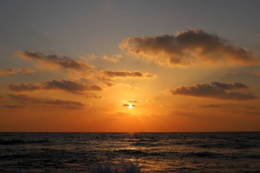 Kuzey İsrail'de Akdeniz'de ufukta güneş batıyor, gündüz bitiyor ve gece çöküyor 