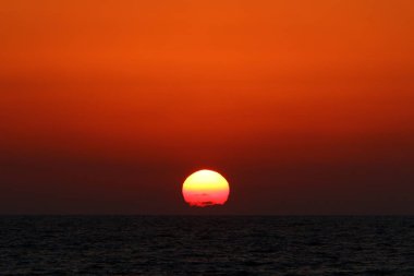 Kuzey İsrail'de Akdeniz'de ufukta güneş batıyor, gündüz bitiyor ve gece çöküyor 