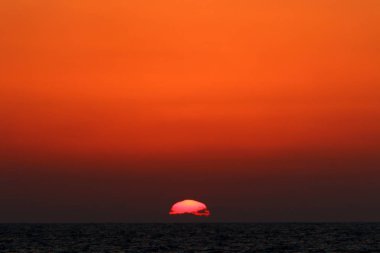 Kuzey İsrail'de Akdeniz'de ufukta güneş batıyor, gündüz bitiyor ve gece çöküyor 