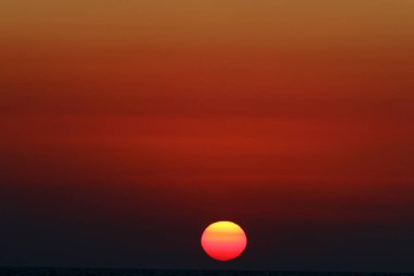 Kuzey İsrail'de Akdeniz'de ufukta güneş batıyor, gündüz bitiyor ve gece çöküyor 