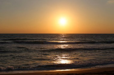 Kuzey İsrail'de Akdeniz'de ufukta güneş batıyor, gündüz bitiyor ve gece çöküyor 