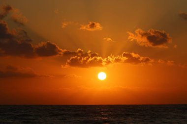 Kuzey İsrail'de Akdeniz'de ufukta güneş batıyor, gündüz bitiyor ve gece çöküyor 