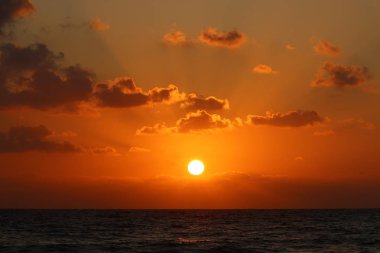 Kuzey İsrail'de Akdeniz'de ufukta güneş batıyor, gündüz bitiyor ve gece çöküyor 