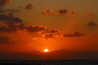 Kuzey İsrail'de Akdeniz'de ufukta güneş batıyor, gündüz bitiyor ve gece çöküyor 