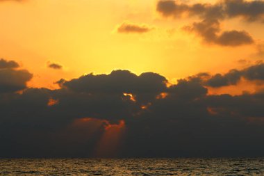 Kuzey İsrail'de Akdeniz'de ufukta güneş batıyor, gündüz bitiyor ve gece çöküyor 