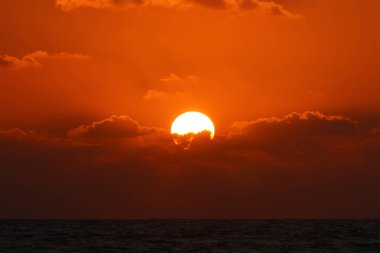 Kuzey İsrail'de Akdeniz'de ufukta güneş batıyor, gündüz bitiyor ve gece çöküyor 