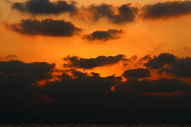 Kuzey İsrail'de Akdeniz'de ufukta güneş batıyor, gündüz bitiyor ve gece çöküyor 