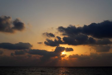 Kuzey İsrail'de Akdeniz'de ufukta güneş batıyor, gündüz bitiyor ve gece çöküyor 