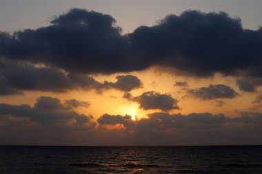 Kuzey İsrail'de Akdeniz'de ufukta güneş batıyor, gündüz bitiyor ve gece çöküyor 