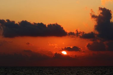 Kuzey İsrail'de Akdeniz'de ufukta güneş batıyor, gündüz bitiyor ve gece çöküyor 
