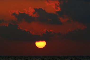 Kuzey İsrail'de Akdeniz'de ufukta güneş batıyor, gündüz bitiyor ve gece çöküyor 