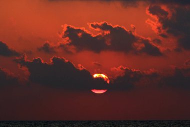 Kuzey İsrail'de Akdeniz'de ufukta güneş batıyor, gündüz bitiyor ve gece çöküyor 