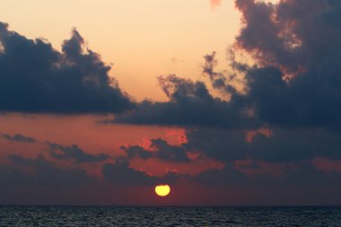 Kuzey İsrail'de Akdeniz'de ufukta güneş batıyor, gündüz bitiyor ve gece çöküyor 